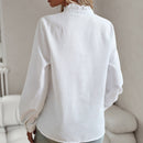 Women's blouse with ruffle accents and clean button front